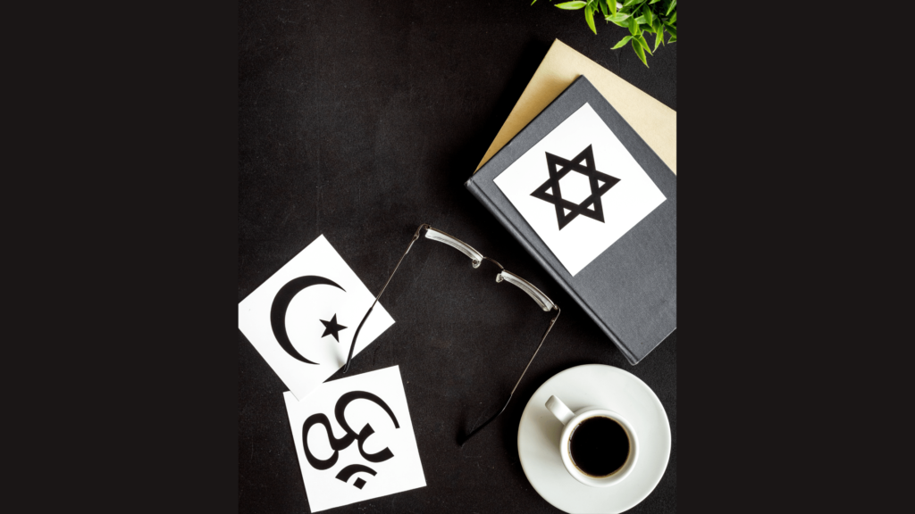 A coffee mug, glasses, and a few notebooks with various religious symbols on them.